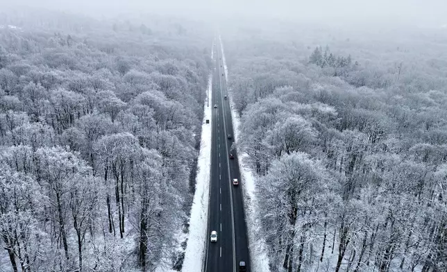 Cars drive through a frozen forest in the Taunus region near Frankfurt, Germany, Wednesday, Jan. 7, 2026. (AP Photo/Michael Probst)