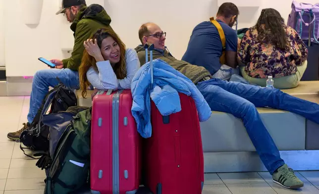 Stranded travellers wait at Schiphol airport in Amsterdam, Netherlands, Wednesday, Jan. 7, 2026, where more than 1,000 stranded passengers spent the night as snow and ice that is pummeling parts of Europe grounded hundreds of flights and choked highways and railroads. (AP Photo/Peter Dejong)