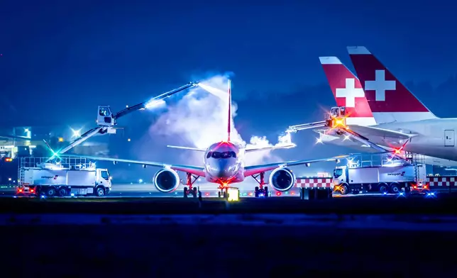 An aircraft of Swiss airlines is de-iced at the airport Zurich, Wednesday, Jan. 7, 2026. (Michael Buholzer/Keystone via AP)
