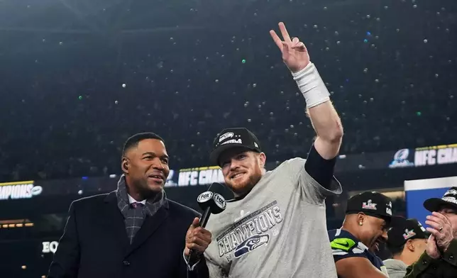 Seattle Seahawks quarterback Sam Darnold, celebrates next to Michael Strahan, left, after a win over the Los Angeles Rams in the NFC Championship NFL football game Sunday, Jan. 25, 2026, in Seattle. (AP Photo/Lindsey Wasson)