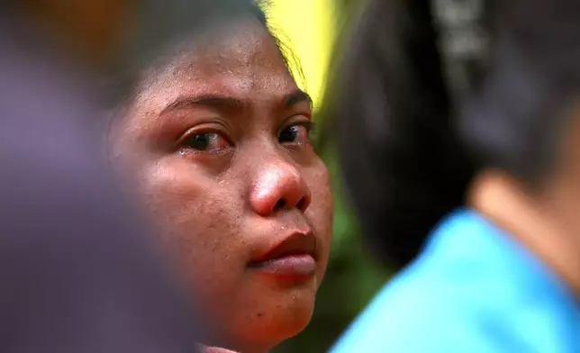 Family members and relatives wait as rescuers continue operations on a collapsed waste segregation facility in Binaliw, Cebu city, central Philippines on Saturday Jan. 10, 2026. (AP Photo/Jacqueline Hernandez)