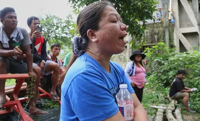 Relatives and others wait for updates after a huge mound of garbage collapsed at a waste segregation facility in Binaliw, Cebu city on Friday, Jan. 9, 2026. (AP Photo/Jacqueline Hernandez)