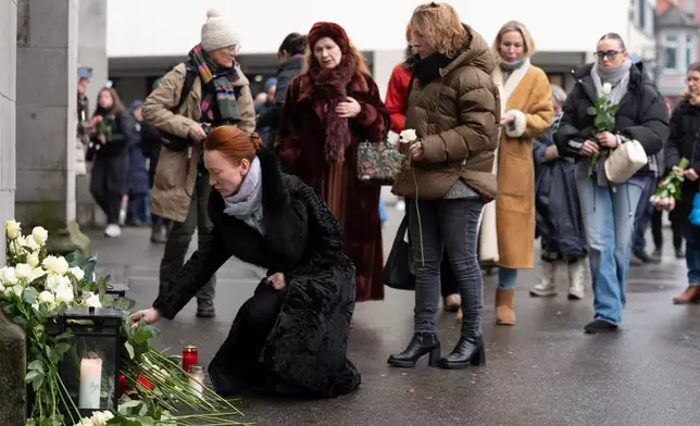 People lay down flowers in tribute to the victims after the official commemorative ceremony for the victims of the deadly fire at the "Le Constellation" bar in Crans-Montana, in Zurich, Switzerland, Friday, Jan. 9, 2026. (Claudio Thoma/Keystone/Pool via AP)
