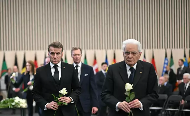 France's President Emmanuel Macron, left, and Italy's President Sergio Mattarella walk with white roses after the tribute ceremony for the victims of the deadly fire that ripped through the bar Le Constellation in Crans-Montana on New Year's Eve, in Martigny, Switzerland, Friday, Jan. 9, 2026. (Fabrice Coffrini/Pool Photo via AP)