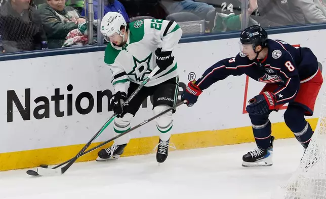 Dallas Stars' Mavrik Bourque, left, controls the puck as Columbus Blue Jackets' Zach Werenski defends during the third period of an NHL hockey game, Thursday, Jan. 22, 2026, in Columbus, Ohio. (AP Photo/Jay LaPrete)