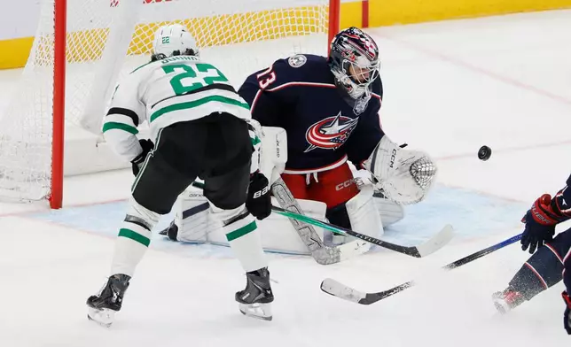 Columbus Blue Jackets' Jet Greaves, center, makes a save against Dallas Stars' Mavrik Bourque during the third period of an NHL hockey game, Thursday, Jan. 22, 2026, in Columbus, Ohio. (AP Photo/Jay LaPrete)