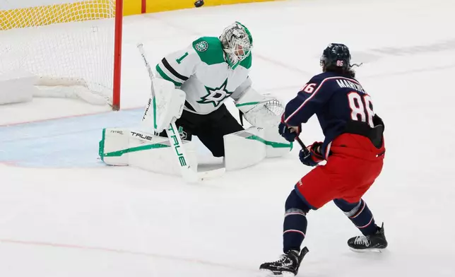 Dallas Stars' Casey DeSmith, left, makes a save against Columbus Blue Jackets' Kirill Marchenko, right, during the second period of an NHL hockey game, Thursday, Jan. 22, 2026, in Columbus, Ohio. (AP Photo/Jay LaPrete)
