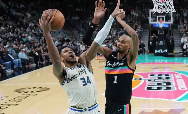 Milwaukee Bucks forward Giannis Antetokounmpo (34) drives to the basket against San Antonio Spurs forward Victor Wembanyama (1) during the first half of an NBA basketball game in San Antonio, Thursday, Jan. 15, 2026. (AP Photo/Eric Gay)