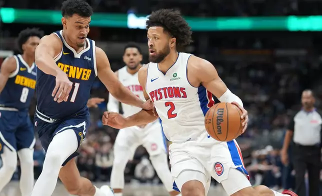 Detroit Pistons guard Cade Cunningham, right, drives past Denver Nuggets forward Spencer Jones in the first half of an NBA basketball game, Tuesday, Jan. 27, 2026, in Denver. (AP Photo/David Zalubowski)