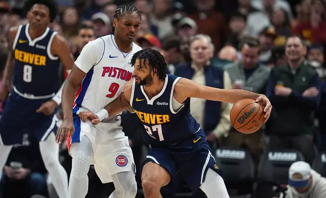 Denver Nuggets guard Jamal Murray, right, drives past Detroit Pistons guard Ausar Thompson in the first half of an NBA basketball game Tuesday, Jan. 27, 2026, in Denver. (AP Photo/David Zalubowski)