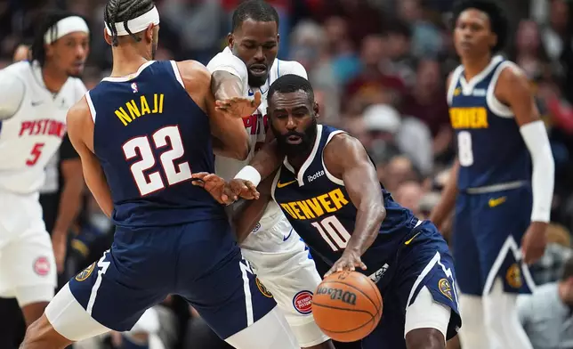 Denver Nuggets guard Tim Hardaway Jr., right, drives past Detroit Pistons guard Javonte Green, center, as Denver center Zeke Nnaji sets a pick in the first half of an NBA basketball game, Tuesday, Jan. 27, 2026, in Denver. (AP Photo/David Zalubowski)