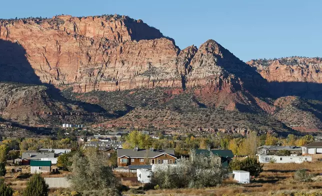 FILE - Hildale, Utah, sitting at the base of Red Rock Cliff mountains, with its sister city, Colorado City, Ariz., in the foreground, on Oct. 26, 2017. (AP Photo/Rick Bowmer, File)