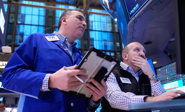 Christopher Lagana and James Denaro work on the floor at the New York Stock Exchange in New York, Friday, Jan. 9, 2026. (AP Photo/Seth Wenig)