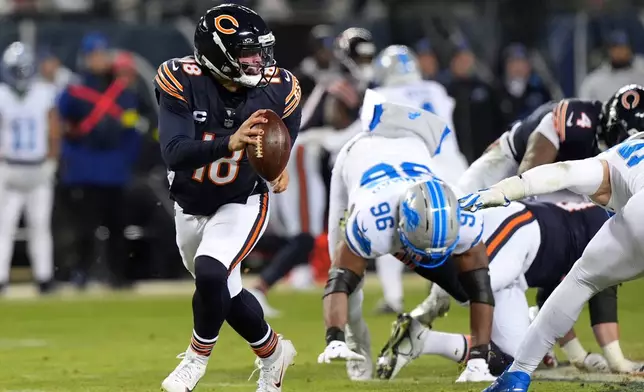 Chicago Bears quarterback Caleb Williams (18) runs from Detroit Lions linebacker al-Quadin Muhammad (96) during the second half of an NFL football game, Sunday, Jan. 4, 2026, in Chicago. (AP Photo/Nam Y. Huh)