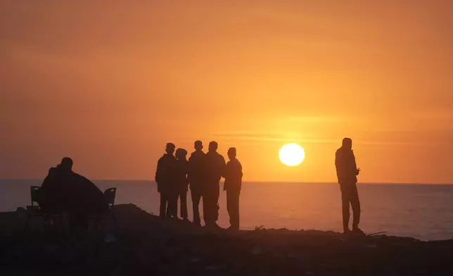 Palestinians watch the sun set over the Mediterranean Sea in Gaza City, Thursday, Jan. 29, 2026. (AP Photo/Jehad Alshrafi)