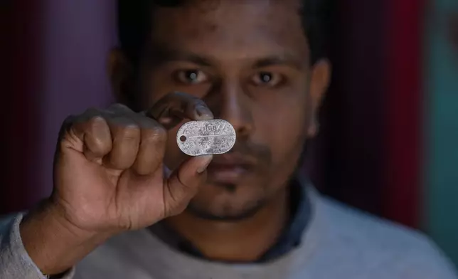 Maksudur Rahman, 31, who escaped after fighting for the Russian army, shows a Russian military dog tag during an interview with The Associated Press in Lakshmipur, Bangladesh, Dec. 10, 2025. (AP Photo/Rajib Dhar)