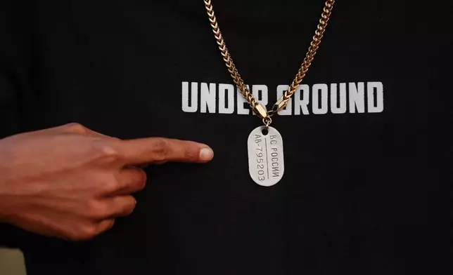 Mohan Miajee, 29, who escaped after fighting for the Russian army, shows his Russian military dog tag in Munshiganj, Bangladesh, Dec. 9, 2025. (AP Photo/Rajib Dhar)