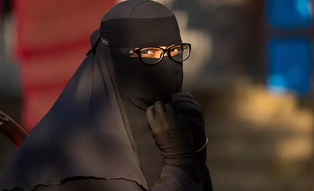 Salma Akdar, 28, who has not heard from her husband Ajgar Hussein, 40, for months, sits after speaking to the Associated Press, in Lakshmipur, Bangladesh, Dec. 10, 2025. (AP Photo/Rajib Dhar)