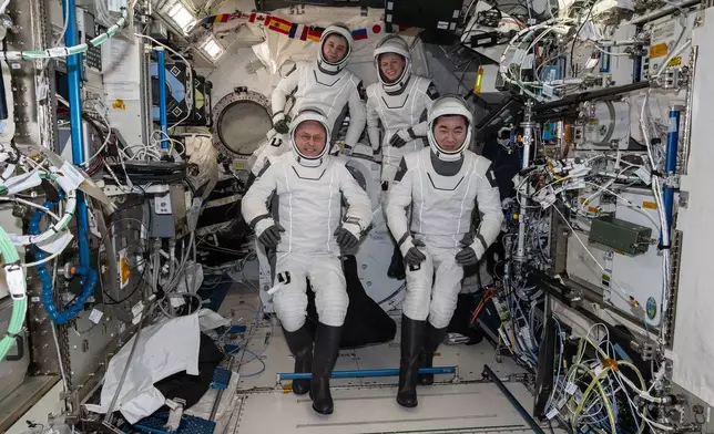 This photo provided by NASA shows clockwise from bottom left are, NASA astronaut Mike Fincke, Roscosmos cosmonaut Oleg Platonov, NASA astronaut Zena Cardman, and JAXA (Japan Aerospace Exploration Agency) astronaut Kimiya Yui gathering for a crew portrait wearing their Dragon pressure suits during a suit verification check inside the International Space Station’s Kibo laboratory module, Wednesday, Jan. 14, 2026. (NASA via AP)