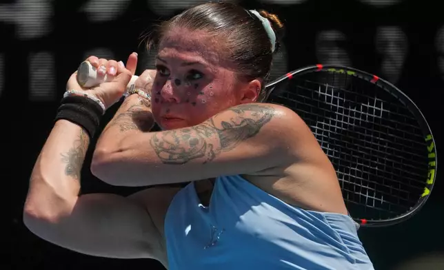 Oleksandra Oliynykova of Ukraine plays a backhand return to Madison Keys of the U.S. during their first round match at the Australian Open tennis championship in Melbourne, Australia, Tuesday, Jan. 20, 2026. (AP Photo/Asanka Brendon Ratnayake)