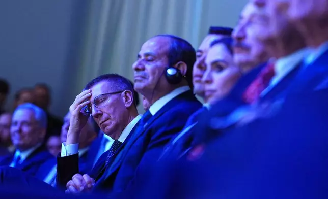 Latvia's President Edgars Rinkevics, left, listens to the address of President Donald Trump during the Annual Meeting of the World Economic Forum in Davos, Switzerland, Wednesday, Jan. 21, 2026. (AP Photo/Evan Vucci)