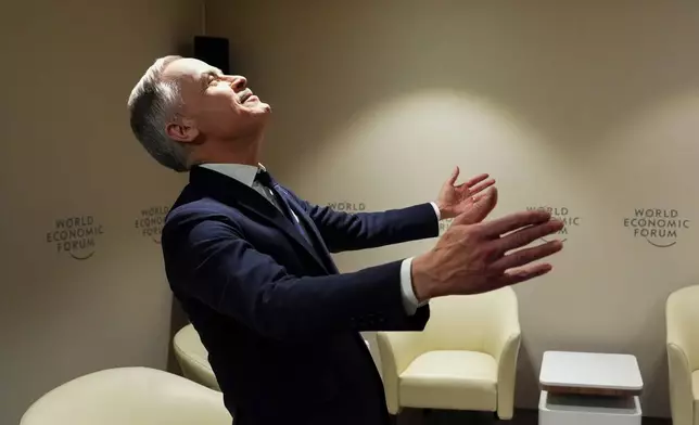 Canadian Prime Minister Mark Carney reacts as French President Emmanuel Macron walks into the room for a meeting during the World Economic Forum in Davos, Switzerland, Tuesday, Jan. 20, 2026. (Sean Kilpatrick/The Canadian Press via AP)