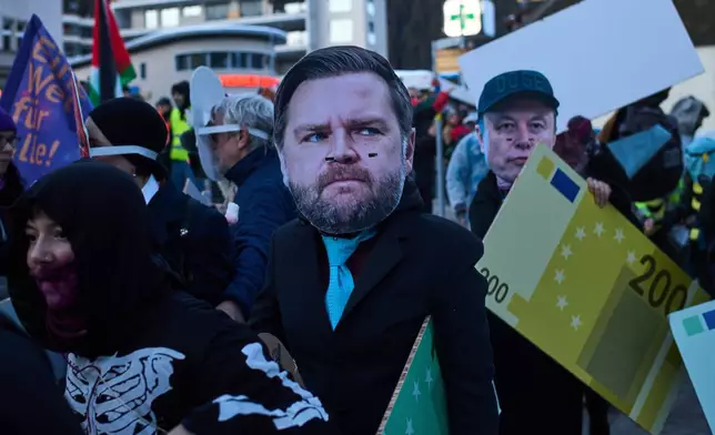 People with masks on Elon Musk, center, and United States Vice President JD Vance, right, attend a demonstration against the United President Donald Trump and the Annual Meeting of the World Economy Forum in Davos, Switzerland, Sunday, Jan. 18, 2026. (AP Photo/Markus Schreiber)