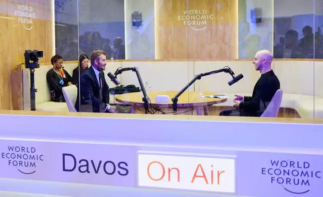 Former soccer player David Beckham, left, speaks with American popular science author Adam Grant, right, in a podcast booth during of the Annual Meeting of the World Economic Forum in Davos, Switzerland, Tuesday, Jan. 20, 2026. (AP Photo/Markus Schreiber)