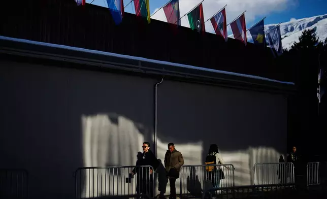 People walk at the Promenade in front of the Congress Center where the Annual Meeting of the World Economy Forum take place in Davos, Switzerland, Monday, Jan. 19, 2026. (AP Photo/Markus Schreiber)