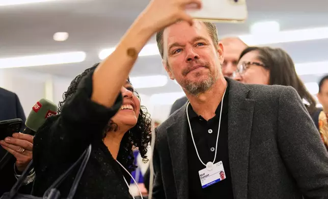 A woman makes a selfie with her phone with American actor Matt Damon during the Annual Meeting of the World Economic Forum in Davos, Switzerland, Tuesday, Jan. 20, 2026. (AP Photo/Markus Schreiber)