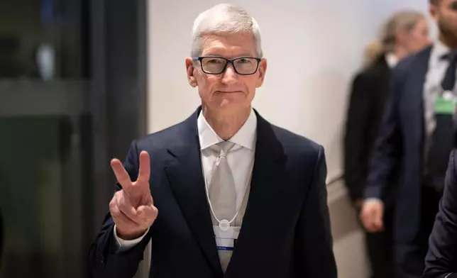 Tim Cook, Apple CEO, makes a victory sign to the photographer in the corridors during the 56th annual meeting of the World Economic Forum, WEF, in Davos, Switzerland, Tuesday, Jan. 20, 2026. (Gian Ehrenzeller/Keystone via AP)