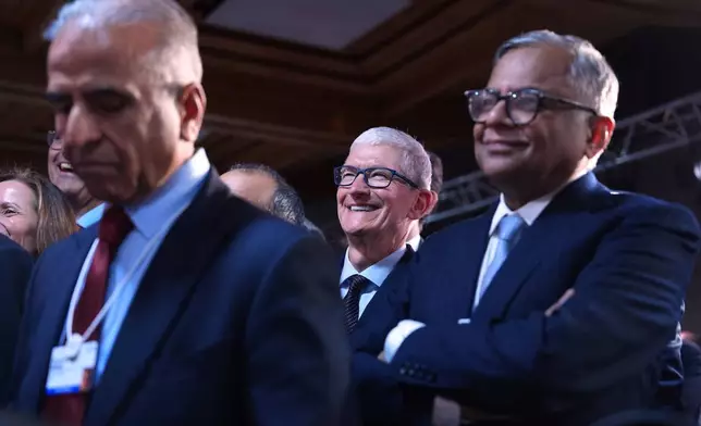 Apple CEO Tim Cook, center, attends a meeting of Global Business Leaders at the Annual Meeting of the World Economic Forum in Davos, Switzerland, Wednesday, Jan. 21, 2026. (AP Photo/Evan Vucci)