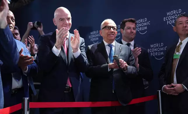 FIFA President Gianni Infantino, center left, applauds after President Donald Trump delivered an address during a meeting of Global Business Leaders at the Annual Meeting of the World Economic Forum in Davos, Switzerland, Wednesday, Jan. 21, 2026. (AP Photo/Evan Vucci)