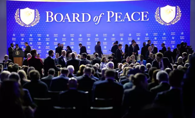 People wait for the start of a session on the Board of Peace initiative of US President Donald Trump at the Annual Meeting of the World Economic Forum in Davos, Switzerland, Thursday, Jan. 22, 2026. (AP Photo/Markus Schreiber)