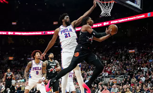 Philadelphia 76ers centre/forward Joel Embiid (21) defends against Toronto Raptors forward Collin Murray-Boyles, right, during the first half of an NBA basketball game in Toronto, Monday, Jan. 12, 2026. (Frank Gunn/The Canadian Press via AP)
