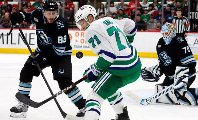 Carolina Hurricanes' Taylor Hall (71) watches the puck with Utah Mammoth's Nate Schmidt (88) nearby during the second period of an NHL hockey game in Raleigh, N.C., Thursday, Jan. 29, 2026. (AP Photo/Karl DeBlaker)
