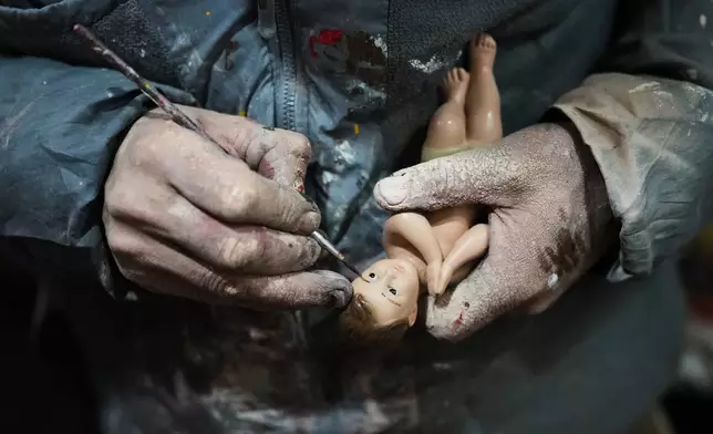Adolfo Vertiz repairs a figurine of Baby Jesus ahead of "Día de la Candelaria," or Candlemas, in Mexico City, Thursday, Jan. 29, 2026. (AP Photo/Eduardo Verdugo)