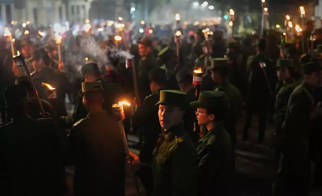 Soldiers march with torches to mark the 173rd anniversary of the birth of national independence hero Jose Marti, in Havana, Tuesday, Jan. 27, 2026. (AP Photo/Ramon Espinosa)