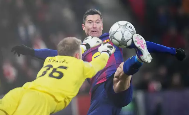 Barcelona's Robert Lewandowski, right, scores his side's fourth goal during the Champions League opening phase soccer match between Slavia Prague and Barcelona in Prague, Czech Republic, Wednesday, Jan. 21, 2026. (AP Photo/Petr David Josek)