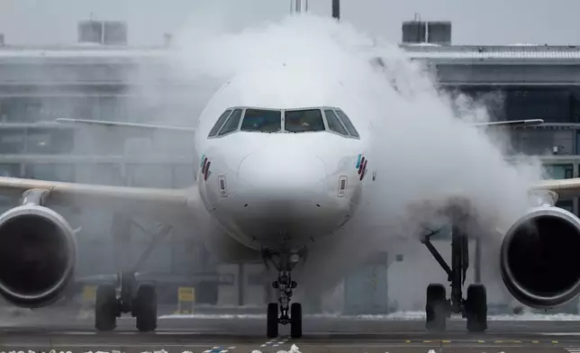 A Eurowings aircraft is de-iced at Berlin-Brandenburg Airport, Germany, Friday Jan. 9, 2026. (Christophe Gateau/dpa via AP)