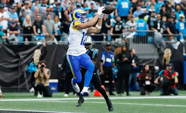 Los Angeles Rams wide receiver Puka Nacua (12) makes a touchdown catch past Carolina Panthers safety Nick Scott (21) during the first half of an NFL Wild Card playoff football game, Saturday, Jan. 10, 2026, in Charlotte, N.C. (AP Photo/Rusty Jones)