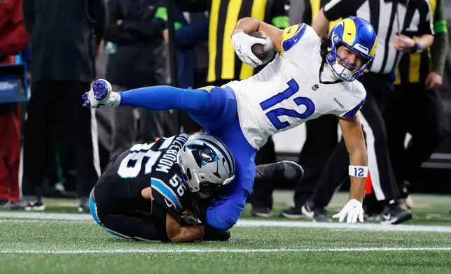 Los Angeles Rams wide receiver Puka Nacua (12) is tackled by Carolina Panthers linebacker Christian Rozeboom (56) during the first half of an NFL wild-card playoff football game, Saturday, Jan. 10, 2026, in Charlotte, N.C. (AP Photo/Rusty Jones)