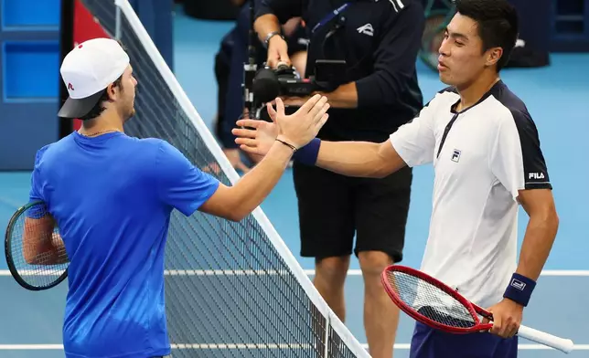 Brandon Nakashima, of the United States, right, shakes hands at the net after he beat Aleksandar Kovacevic, of the United States, left, in their semifinal match at the Brisbane International tennis tournament in Brisbane, Australia, Saturday, Jan. 10, 2026. (AP Photo/Tertius Pickard)
