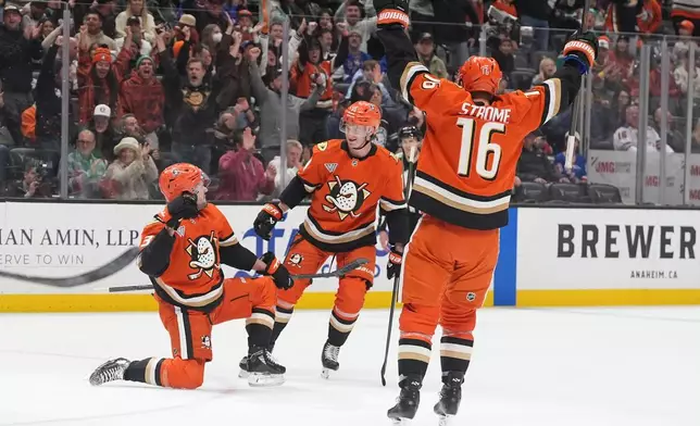 Anaheim Ducks center Mason McTavish, left, celebrates his goal with teammates defenseman Drew Helleson, center, and center Ryan Strome during the first period of an NHL hockey game against the New York Rangers Monday, Jan. 19, 2026, in Anaheim, Calif. (AP Photo/Gregory Bull)