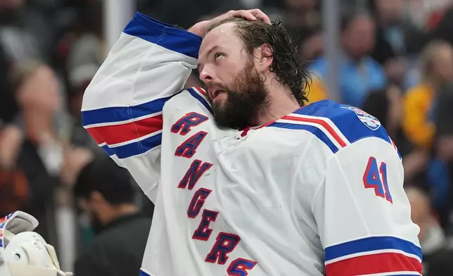 New York Rangers goaltender Spencer Martin takes off his helmet during a break in the first period of an NHL hockey game against the Anaheim Ducks Monday, Jan. 19, 2026, in Anaheim, Calif. (AP Photo/Gregory Bull)