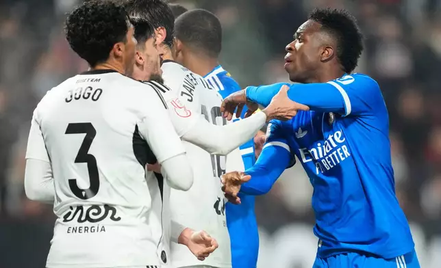 Real Madrid's Vinicius Junior argues with Albacete's players during the Copa del Rey round of 16 soccer match between Albacete and Real Madrid, in Albacete, Spain, Wednesday, Jan. 14, 2026. (AP Photo/Jose Breton)