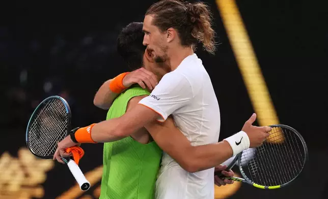 Carlos Alcaraz of Spain is congratulated by Alexander Zverev, right, of Germany following their semifinal match at the Australian Open tennis championship in Melbourne, Australia, Friday, Jan. 30, 2026. (AP Photo/Dita Alangakra)