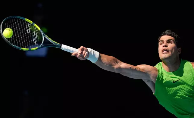 Carlos Alcaraz of Spain plays a forehand return to Alexander Zverev of Germany during their semifinal match at the Australian Open tennis championship in Melbourne, Australia, Friday, Jan. 30, 2026. (AP Photo/Asanka Brendon Ratnayake)