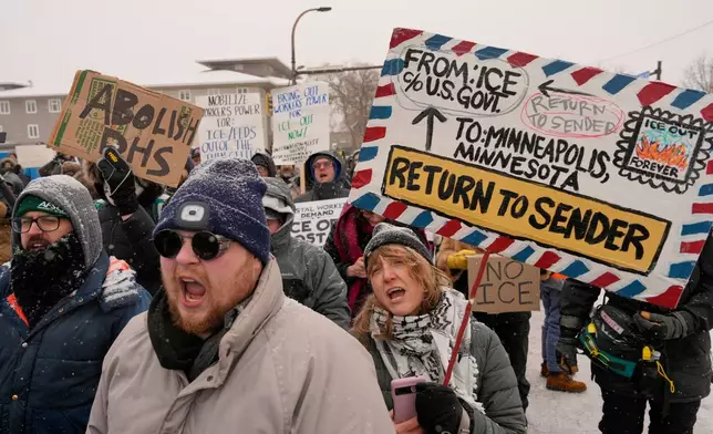 People march and gather near the post office during a protest, Sunday, Jan. 18, 2026, in Minneapolis. (AP Photo/Yuki Iwamura)