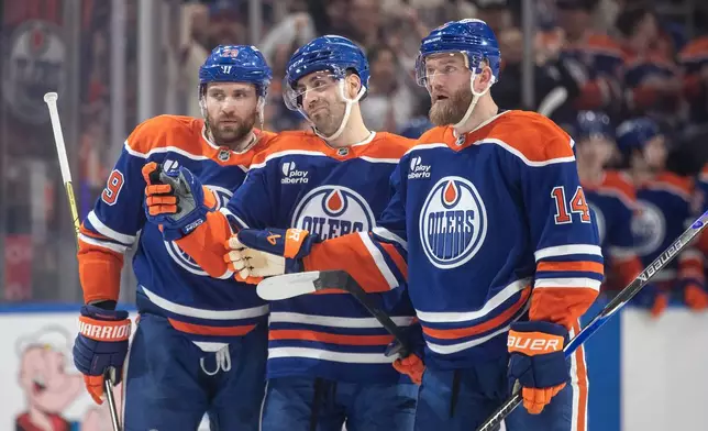 Edmonton Oilers' Leon Draisaitl (29), Evan Bouchard, center, and Mattias Ekholm (14) celebrate after a goal against the Washington Capitals during second-period NHL hockey game action in Edmonton, Alberta, Saturday, Jan. 24, 2026. (Jason Franson/The Canadian Press via AP)